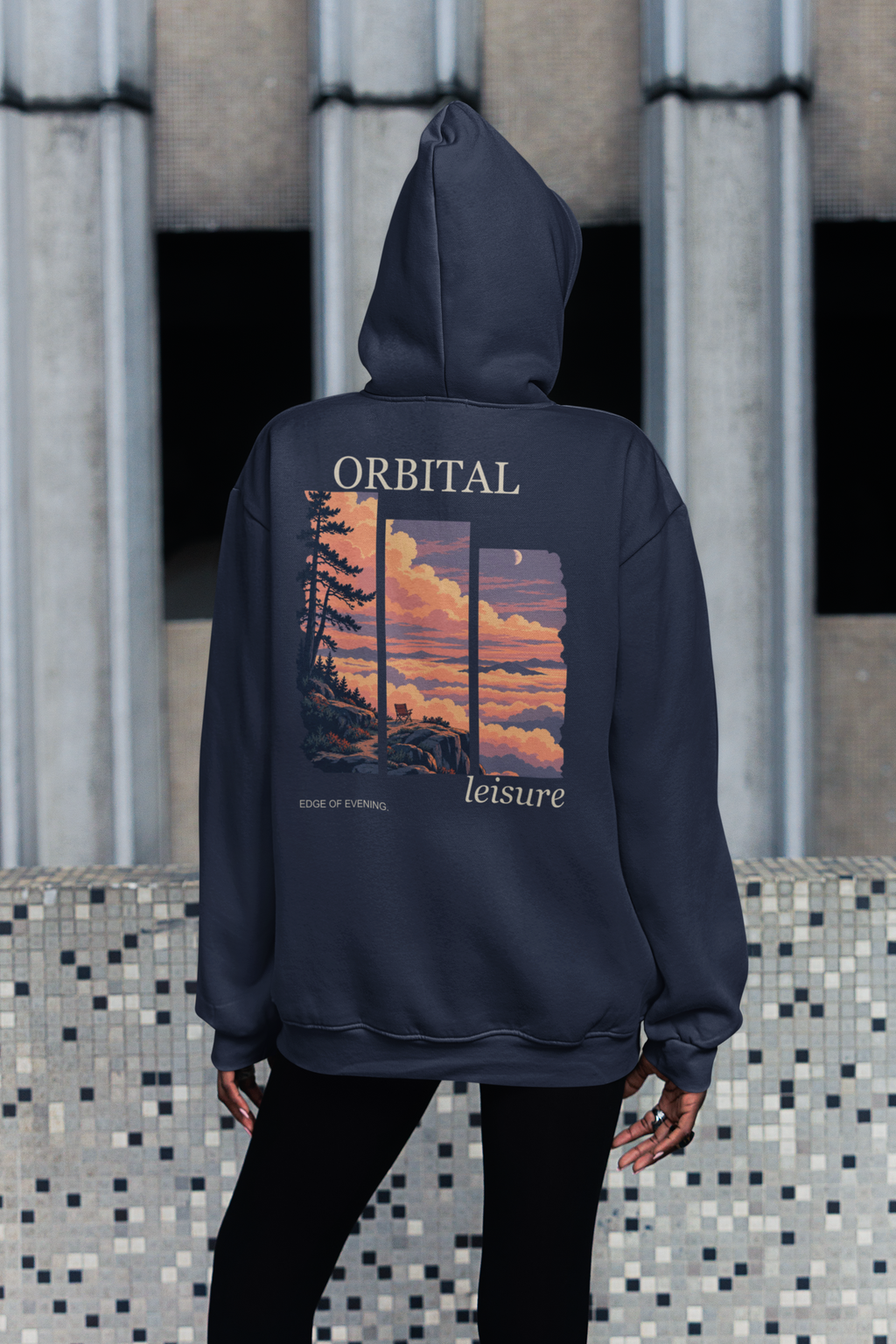 Edge of Evening Zip Hoodie in Navy, worn by a woman seen from behind on a city sidewalk, showing the large print on the back. Digital product mockup.