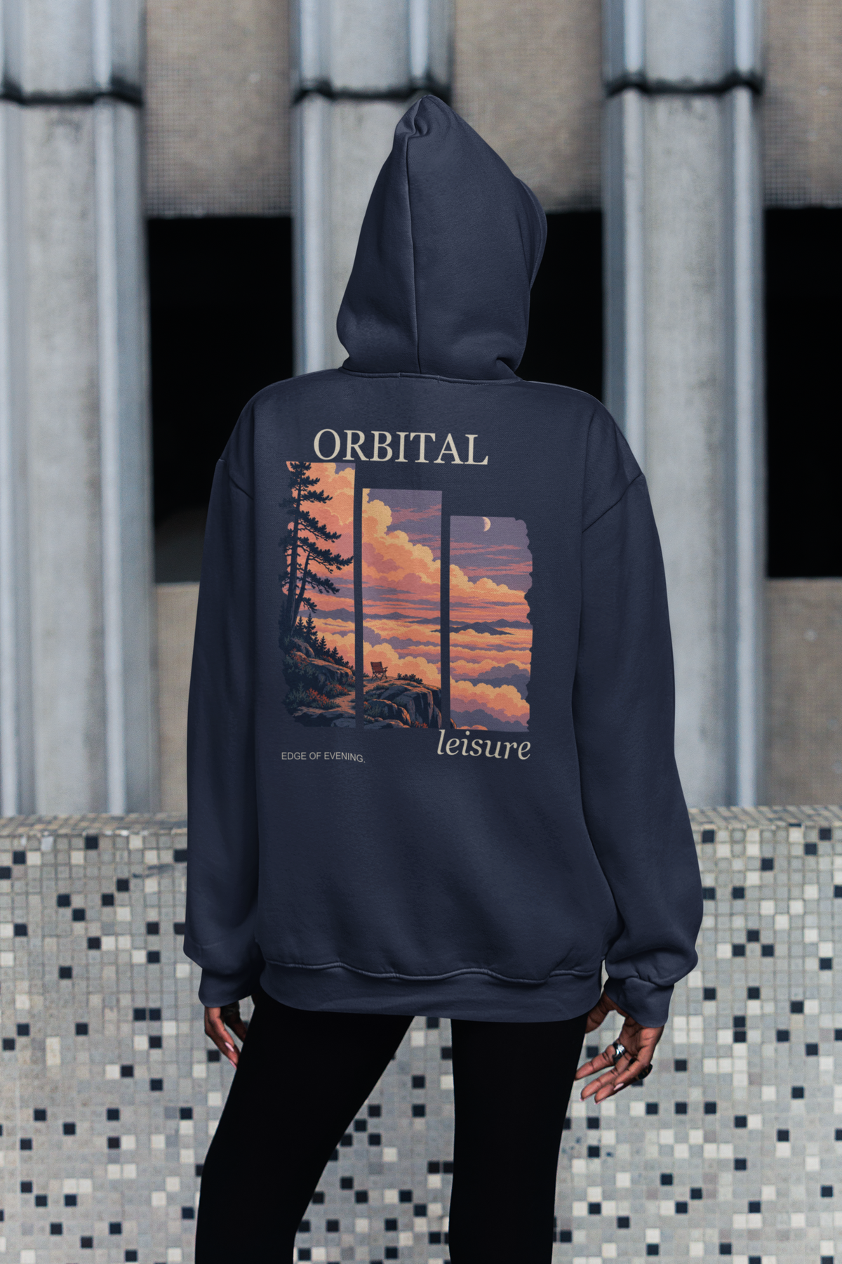 Edge of Evening Zip Hoodie in Navy, worn by a woman seen from behind on a city sidewalk, showing the large print on the back. Digital product mockup.