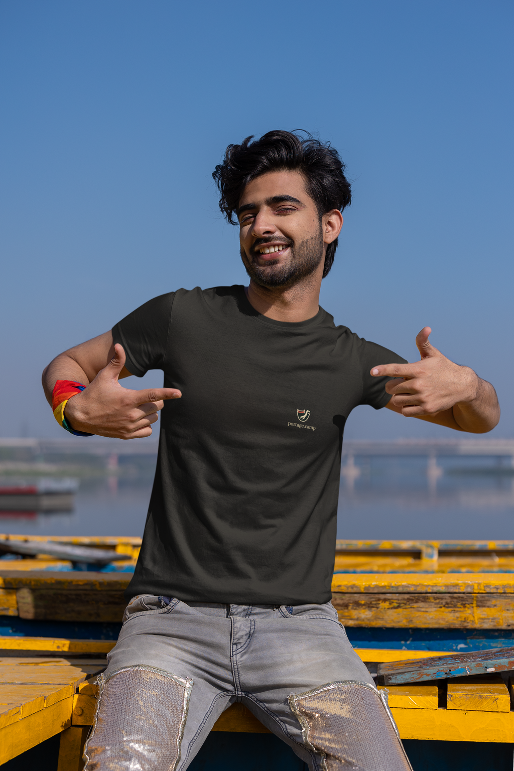 Seen Briefly Garment-Dyed Tee in Black, worn by a man on a city street, with the Seen Briefly logo and portage.camp on the chest. Digital product mockup.