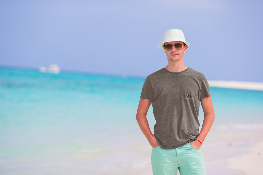 Quiet Hours Garment-Dyed Tee in Espresso, worn by a man on a sunny beach, with the Quiet Hours logo and portage.camp on the chest. Digital product mockup.