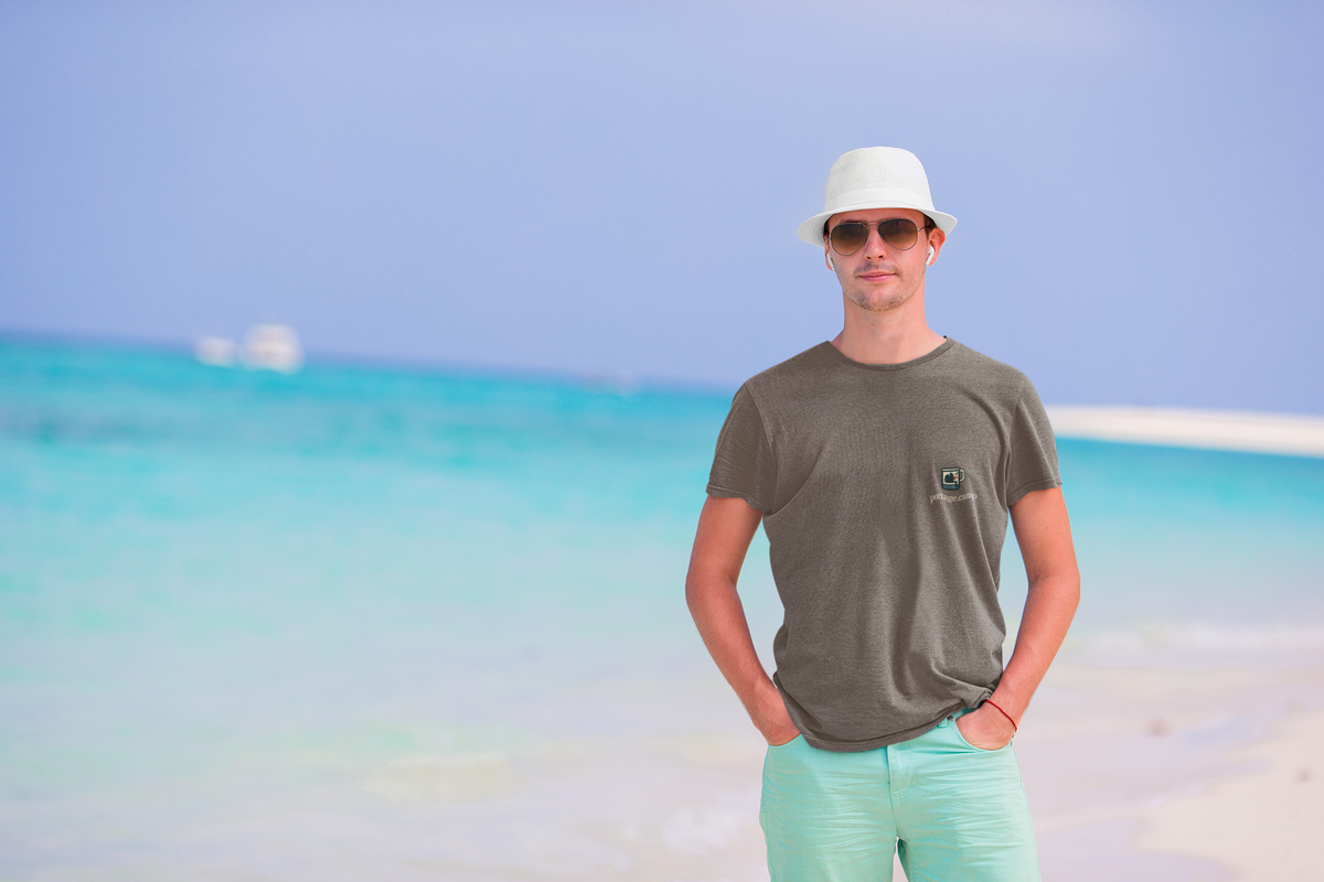 Quiet Hours Garment-Dyed Tee in Espresso, worn by a man on a sunny beach, with the Quiet Hours logo and portage.camp on the chest. Digital product mockup.