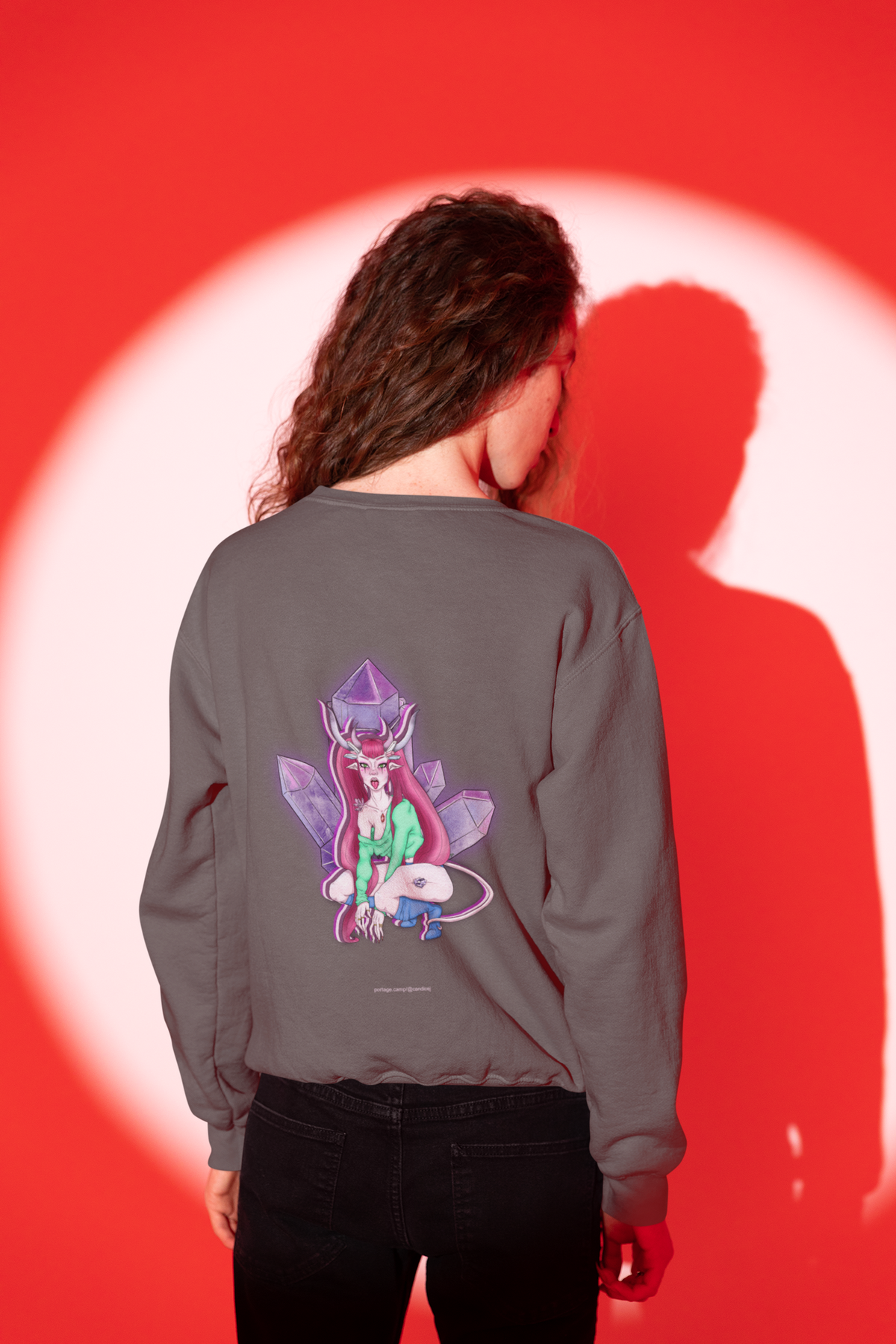 Heart Thief Garment-Dyed Crewneck in Pepper, worn by a man seen from behind in a studio, his shadow on the wall behind him, showing the large print on the back. Digital product mockup.