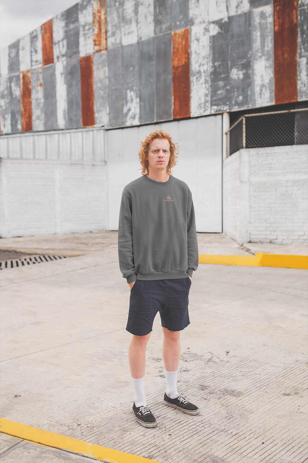 Edge of Evening Garment-Dyed Crewneck in Pepper, worn by a man against a plain wall, with the Edge of Evening logo and portage.camp on the chest. Digital product mockup.