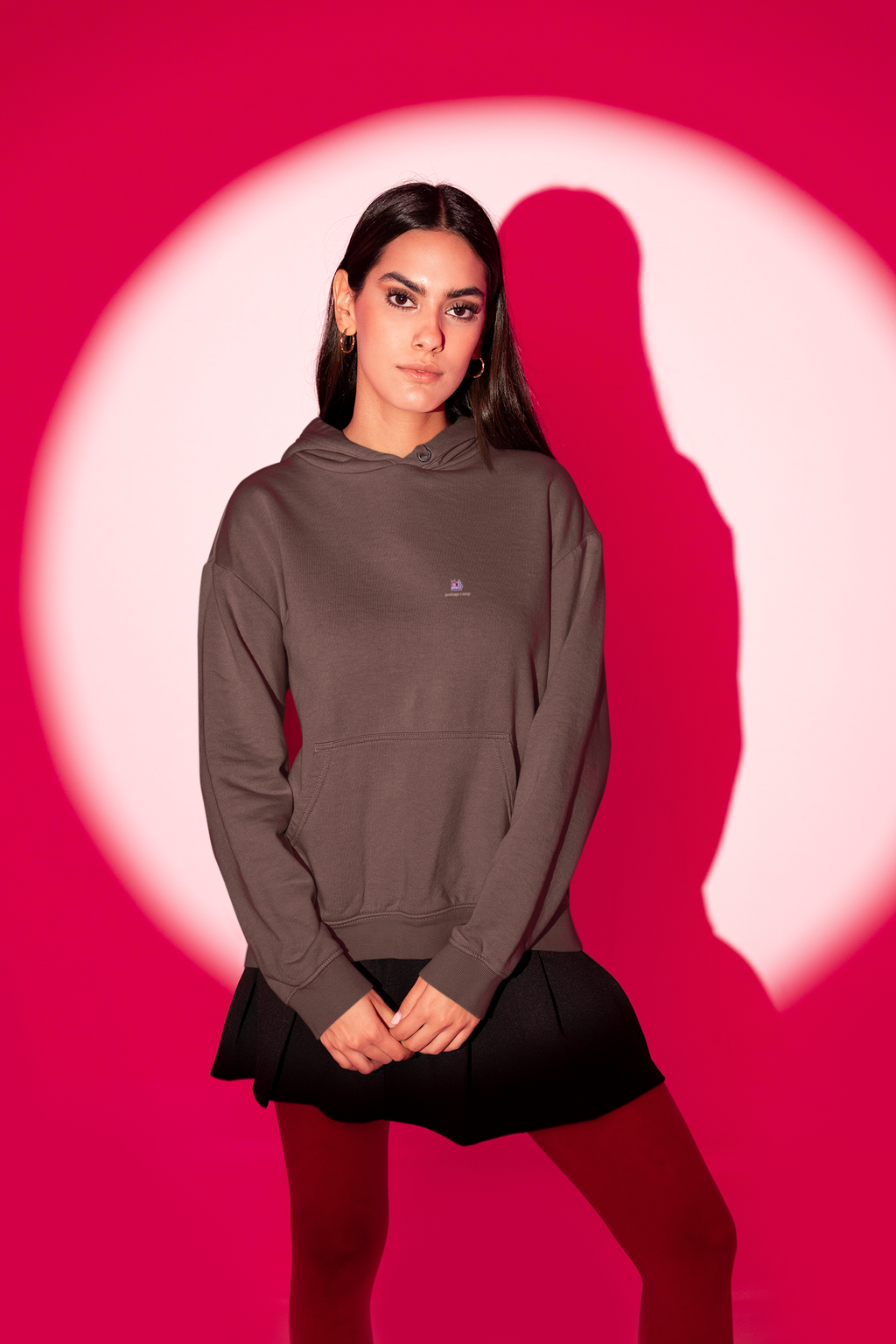 Amethyst After Hours Heavyweight Hoodie in Brown, worn by a woman in a red-lit studio, with the Amethyst After Hours logo and portage.camp on the left chest. Digital product mockup.