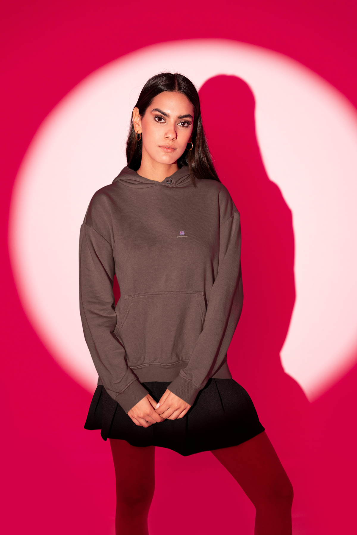 Amethyst After Hours Heavyweight Hoodie in Brown, worn by a woman in a red-lit studio, with the Amethyst After Hours logo and portage.camp on the left chest. Digital product mockup.