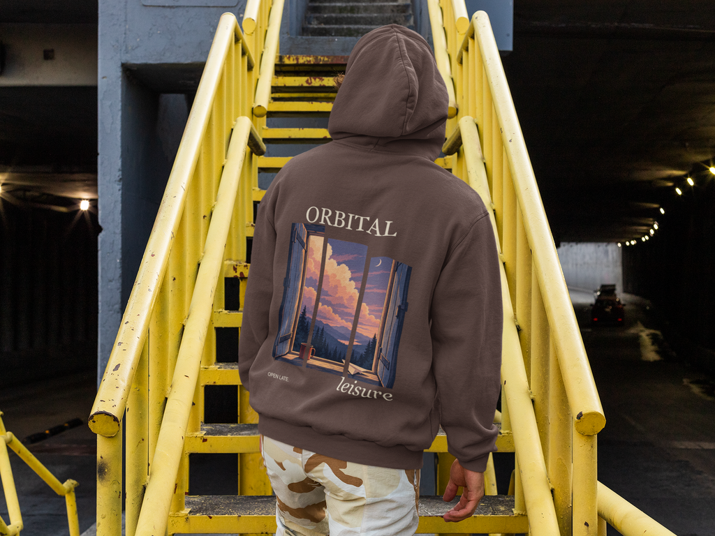 Cloud Ferry Heavyweight Hoodie in Brown, worn by a man seen from behind climbing a yellow metal staircase, showing the large print on the back. Digital product mockup.