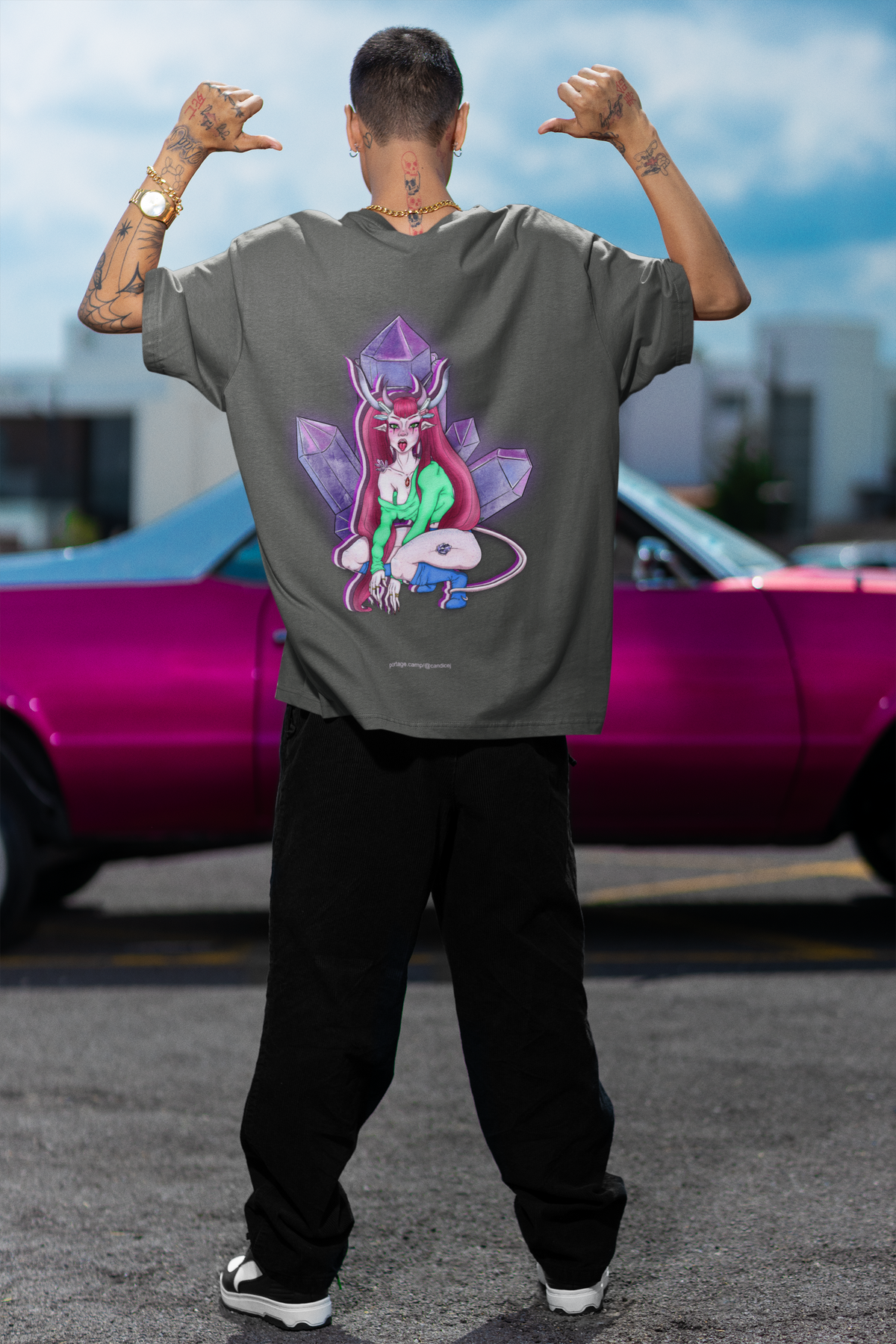 Amethyst After Hours Garment-Dyed Tee in Pepper, worn by a man seen from behind by a pink car, showing the large print on the back. Digital product mockup.