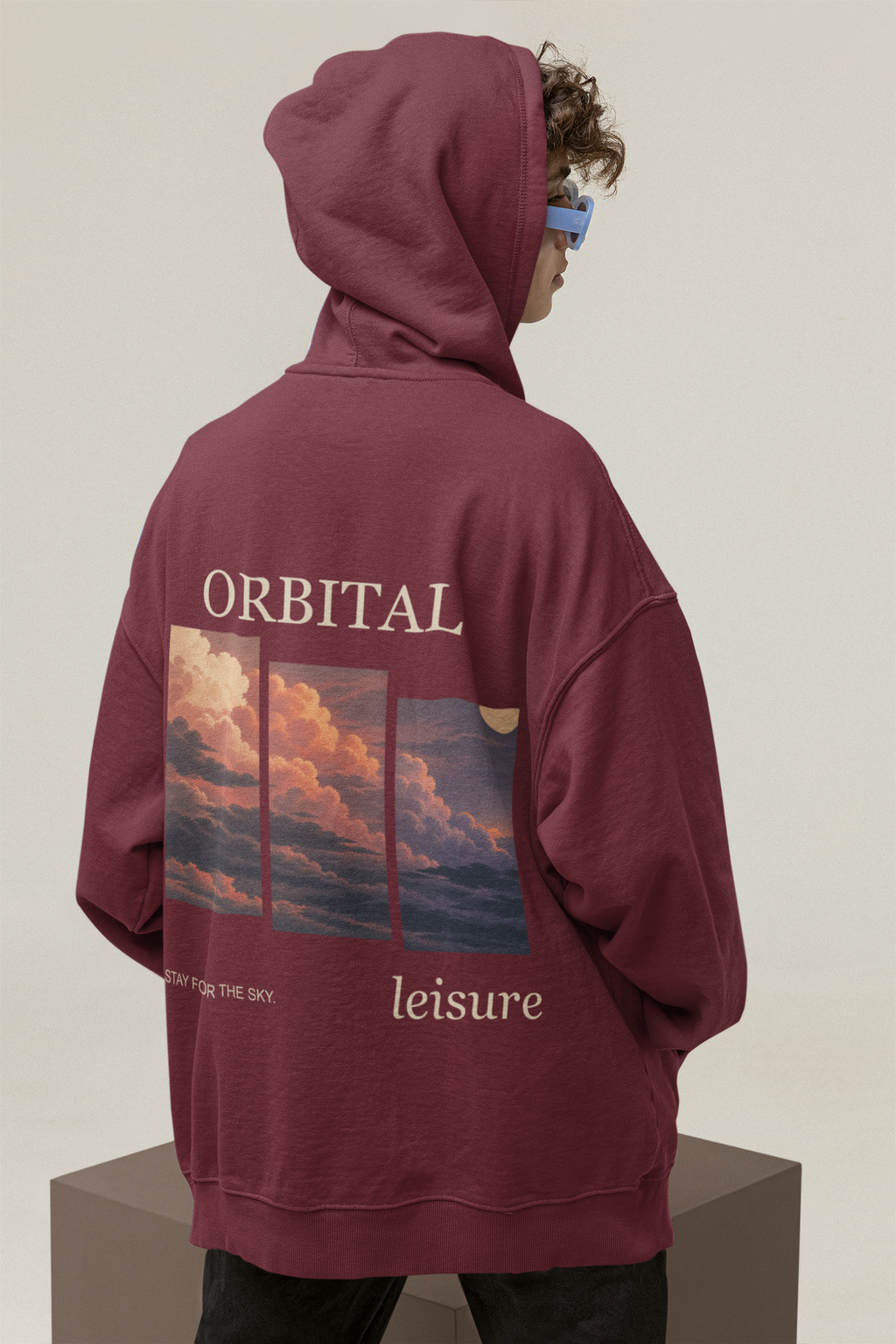 Stay for the Sky Midweight Hoodie in Maroon, worn by a man seen from behind in a studio with the hood up, showing the large print on the back. Digital product mockup.