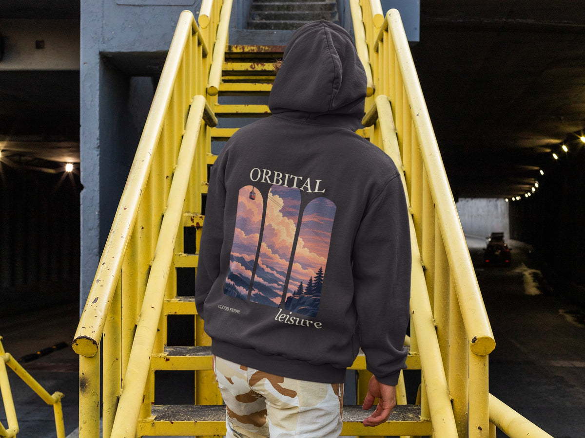 Cloud Ferry Midweight Hoodie in Black, worn by a man seen from behind climbing a yellow metal staircase, showing the large print on the back. Digital product mockup.