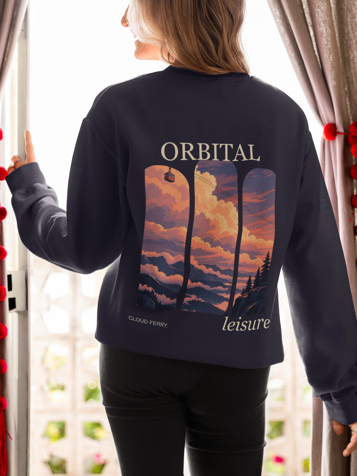 Cloud Ferry Garment-Dyed Crewneck in True Navy, worn by a woman seen from behind at an open door, showing the large print on the back. Digital product mockup.
