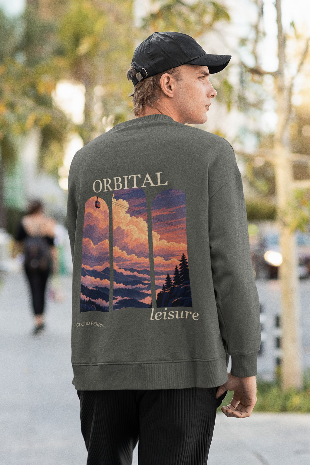 Cloud Ferry Garment-Dyed Crewneck in Pepper, worn by a man seen from behind walking down a city street, showing the large print on the back. Digital product mockup.