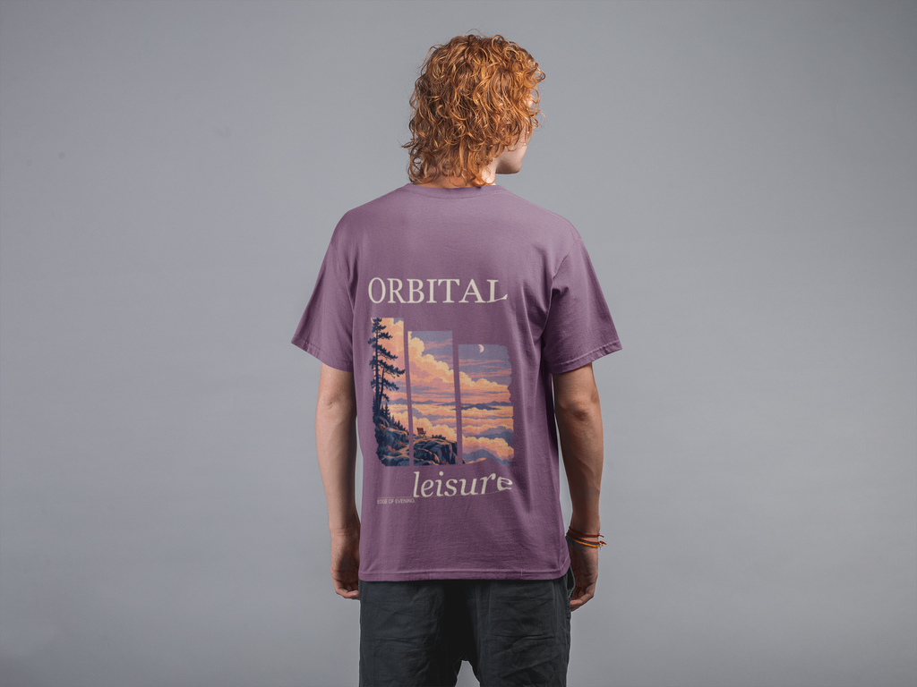 Edge of Evening Garment-Dyed Tee in Berry, worn by a man seen from behind against a plain grey wall, showing the large print on the back. Digital product mockup.