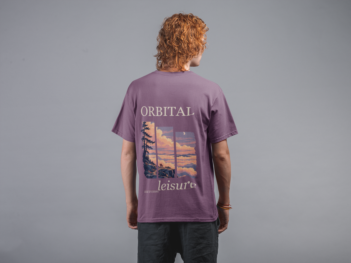 Edge of Evening Garment-Dyed Tee in Berry, worn by a man seen from behind against a plain grey wall, showing the large print on the back. Digital product mockup.
