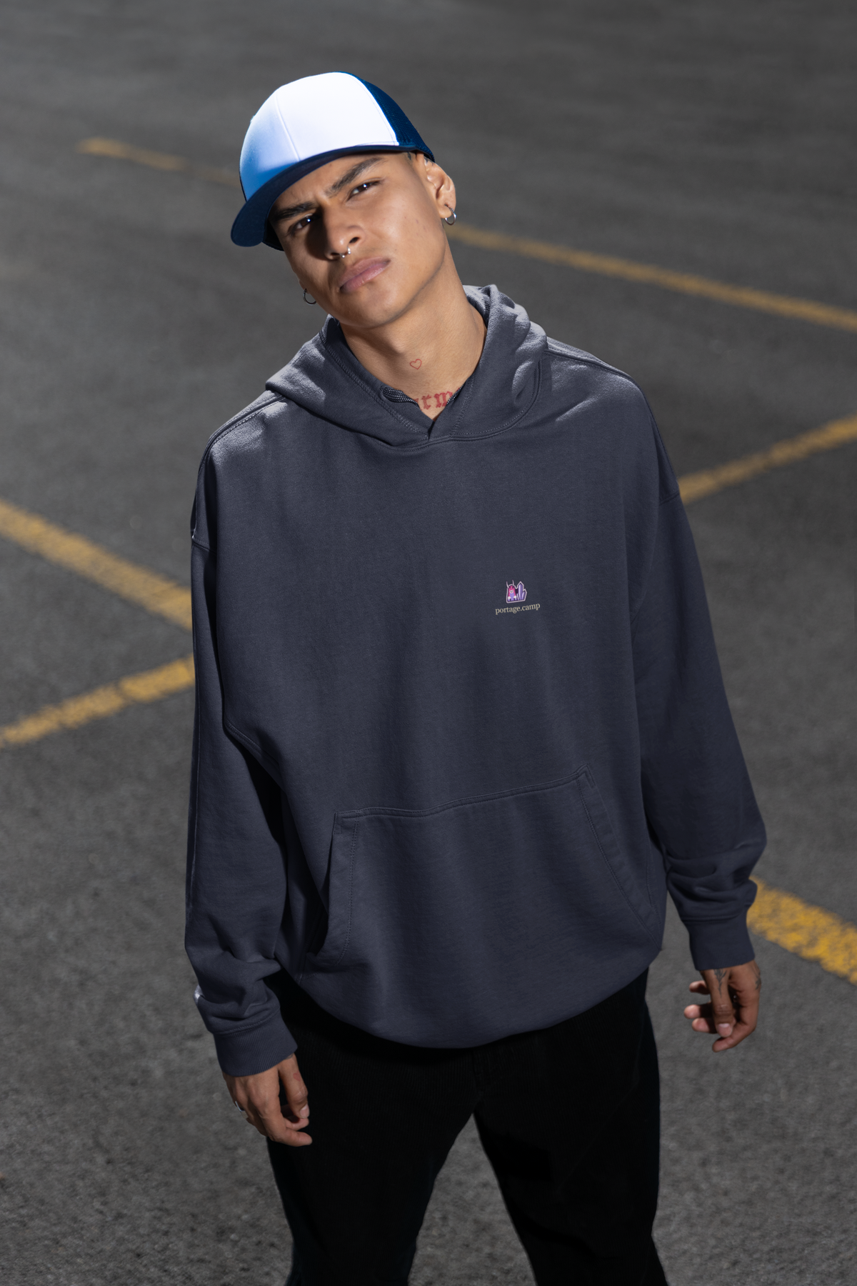 Amethyst After Hours Midweight Hoodie in Classic Navy, worn by a man in a parking lot, with the Amethyst After Hours logo and portage.camp on the chest. Digital product mockup.