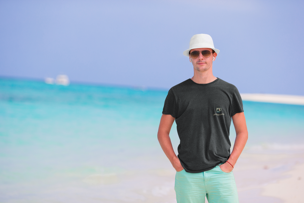 Quiet Hours Garment-Dyed Tee in Black, worn by a man on a sunny beach, with the Quiet Hours logo and portage.camp on the chest. Digital product mockup.