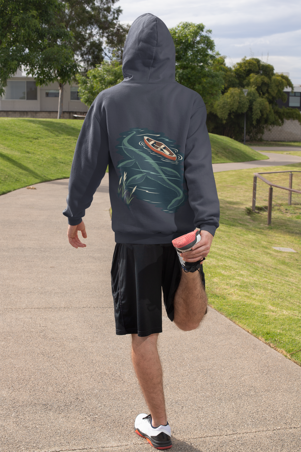 Seen Briefly Midweight Hoodie in Classic Navy, worn by a man seen from behind on a sunny path, ready for a run, showing the large print on the back. Digital product mockup.