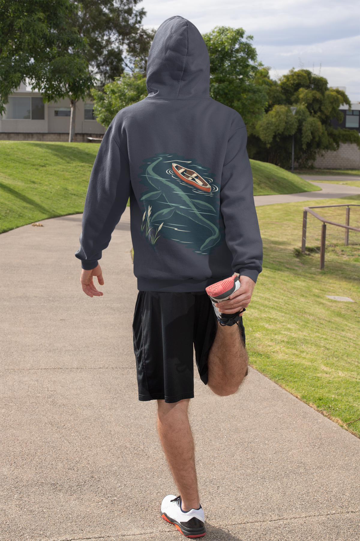 Seen Briefly Midweight Hoodie in Classic Navy, worn by a man seen from behind on a sunny path, ready for a run, showing the large print on the back. Digital product mockup.