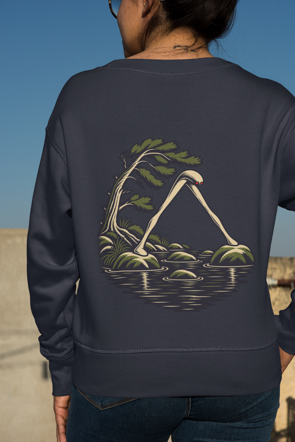 Small Hours Garment-Dyed Crewneck in True Navy, worn by a woman seen from behind against a plain backdrop, showing the large print on the back. Digital product mockup.