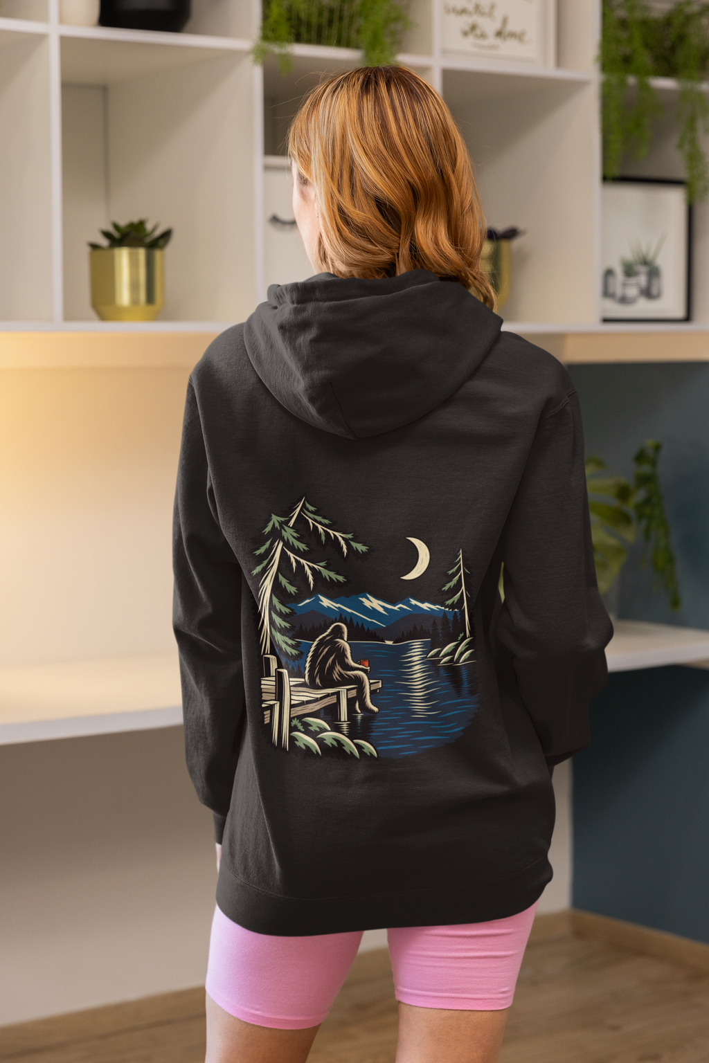 Quiet Hours Zip Hoodie in Black, worn by a woman seen from behind at home, showing the large print on the back. Digital product mockup.