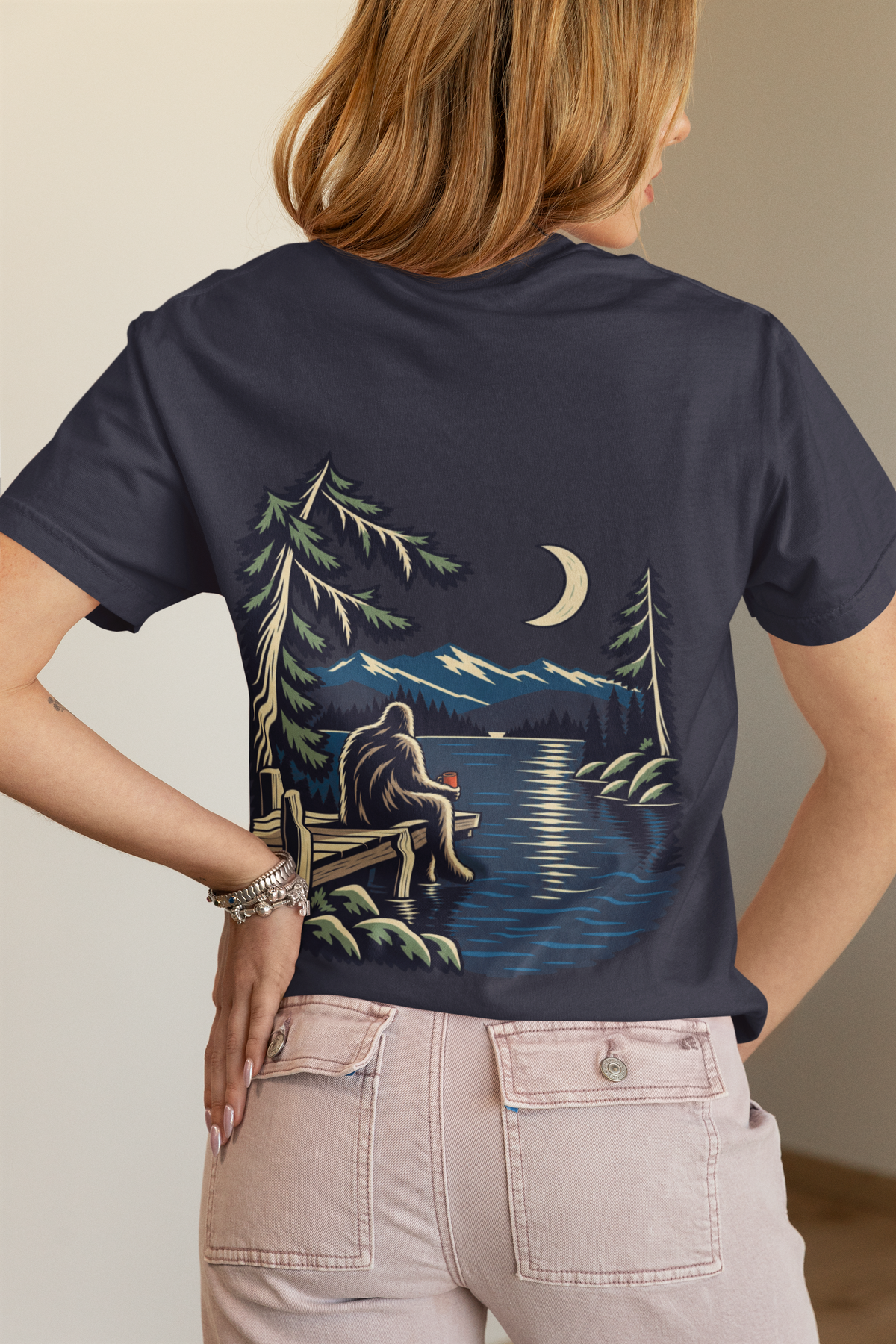Quiet Hours Women’s Relaxed Tee in Navy, worn by a woman seen from behind in a bedroom at home, showing the large print on the back. Digital product mockup.