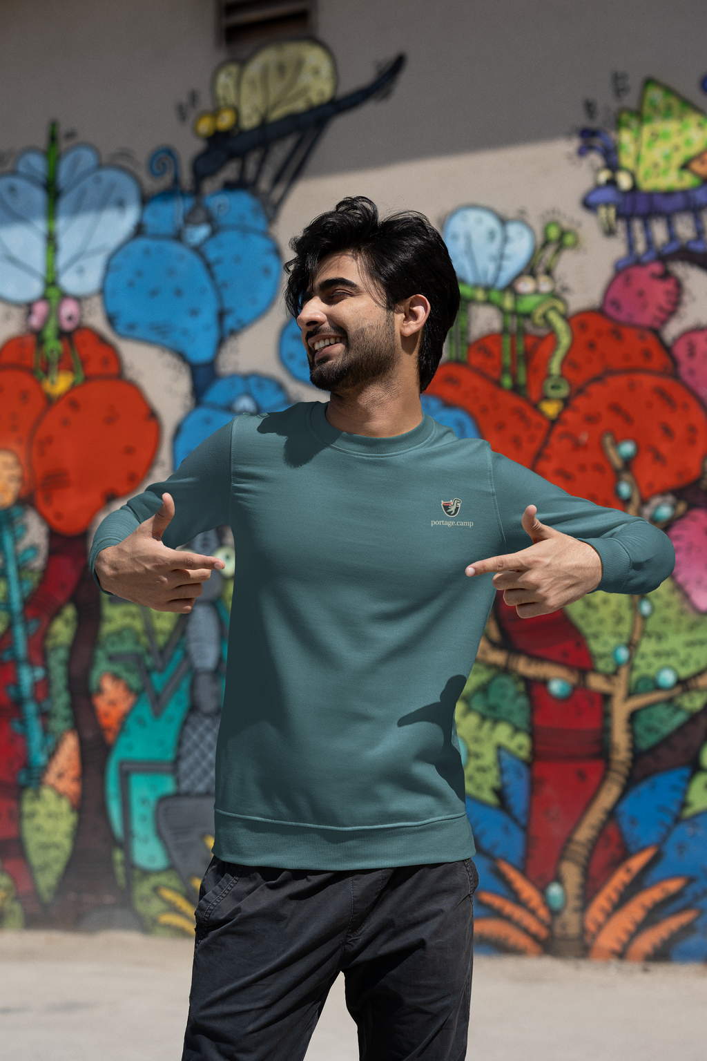 Seen Briefly Garment-Dyed Crewneck in Blue Spruce, worn by a man on a city street, with the Seen Briefly logo and portage.camp on the chest. Digital product mockup.
