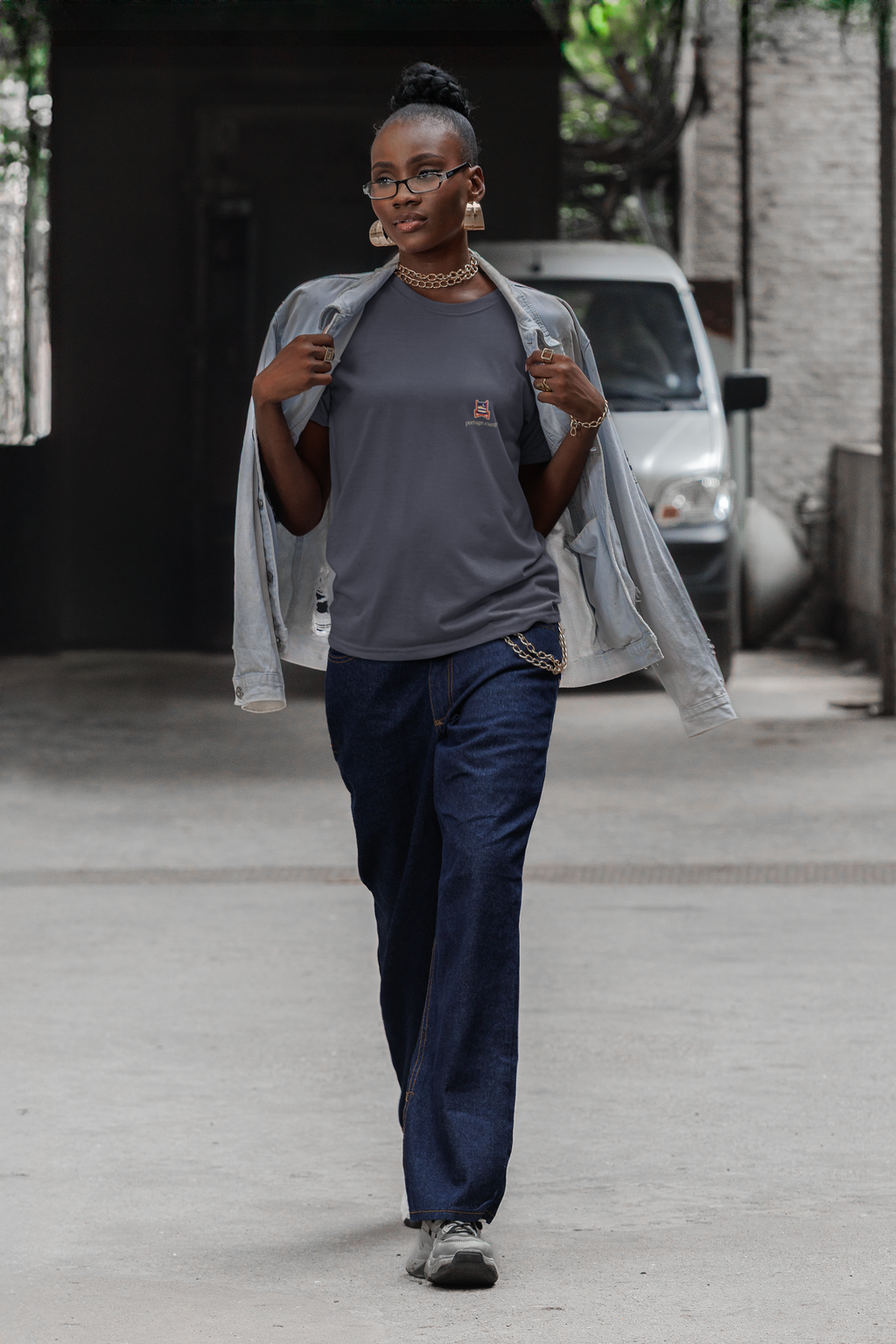 Edge of Evening Garment-Dyed Tee in Navy, worn by a woman walking down a city street, with the Edge of Evening logo and portage.camp on the chest. Digital product mockup.