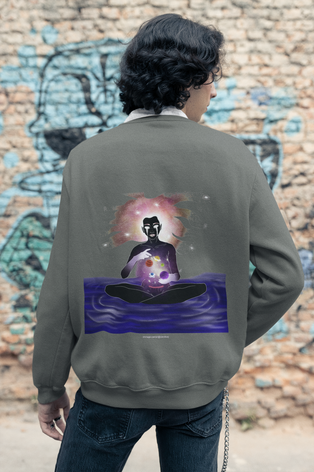 Orbit Keeper Garment-Dyed Crewneck in Pepper, worn by a man seen from behind in a studio, showing the large print on the back. Digital product mockup.