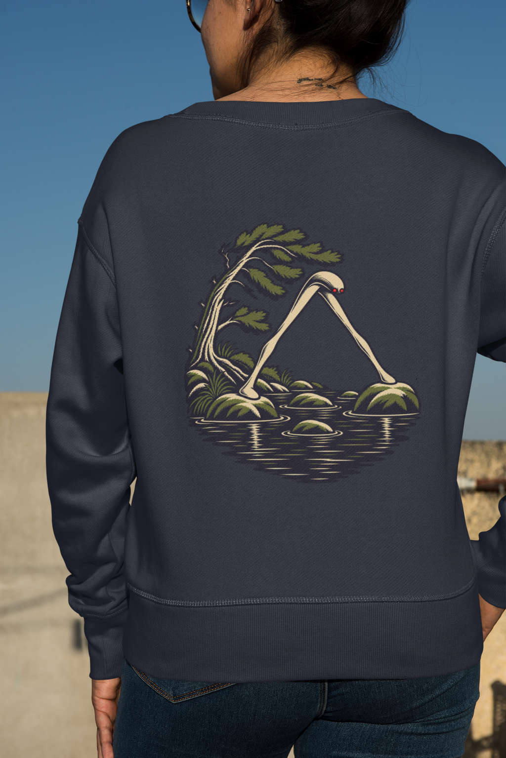 Small Hours Garment-Dyed Crewneck in True Navy, worn by a woman seen from behind against a plain backdrop, showing the large print on the back. Digital product mockup.