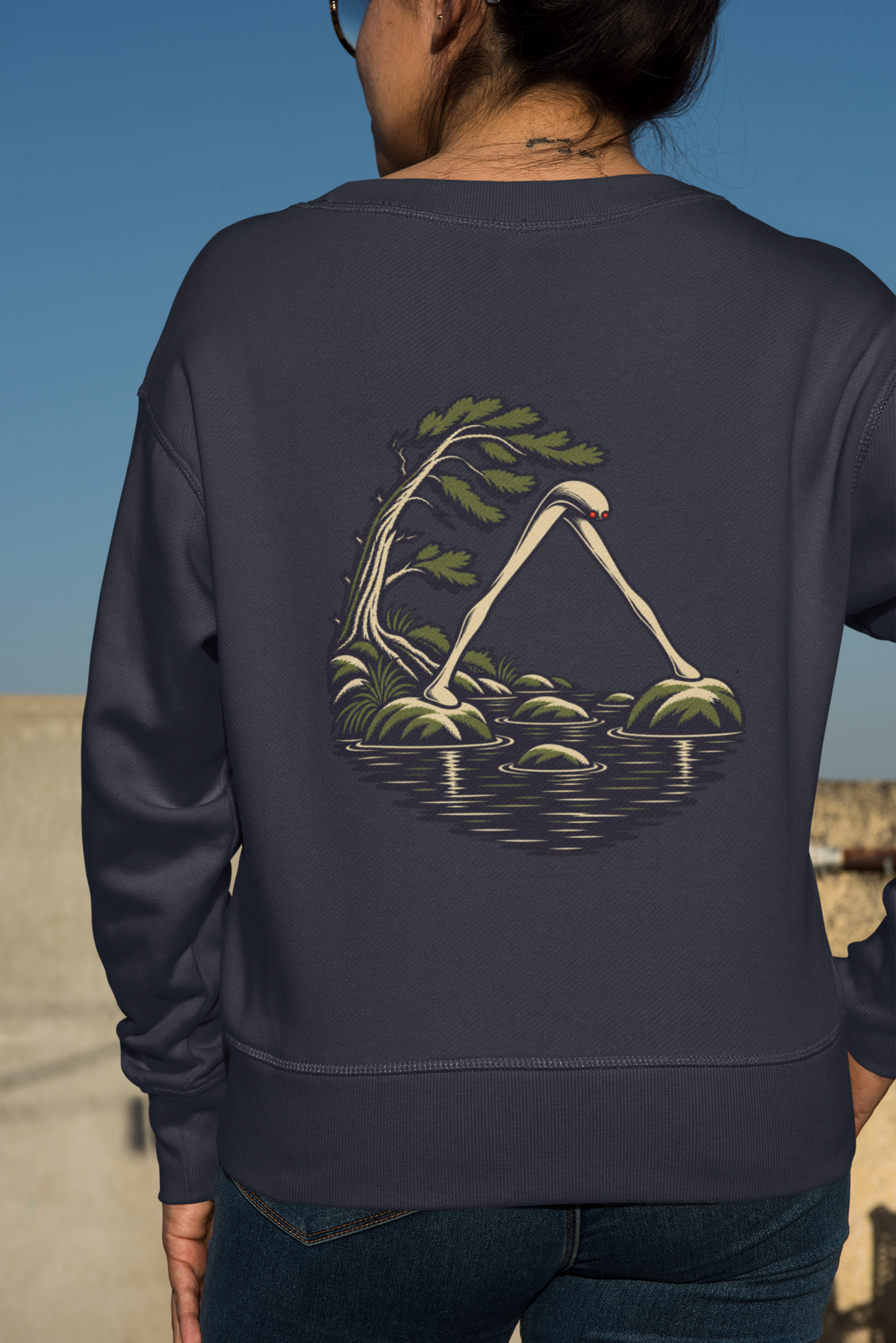 Small Hours Garment-Dyed Crewneck in True Navy, worn by a woman seen from behind against a plain backdrop, showing the large print on the back. Digital product mockup.