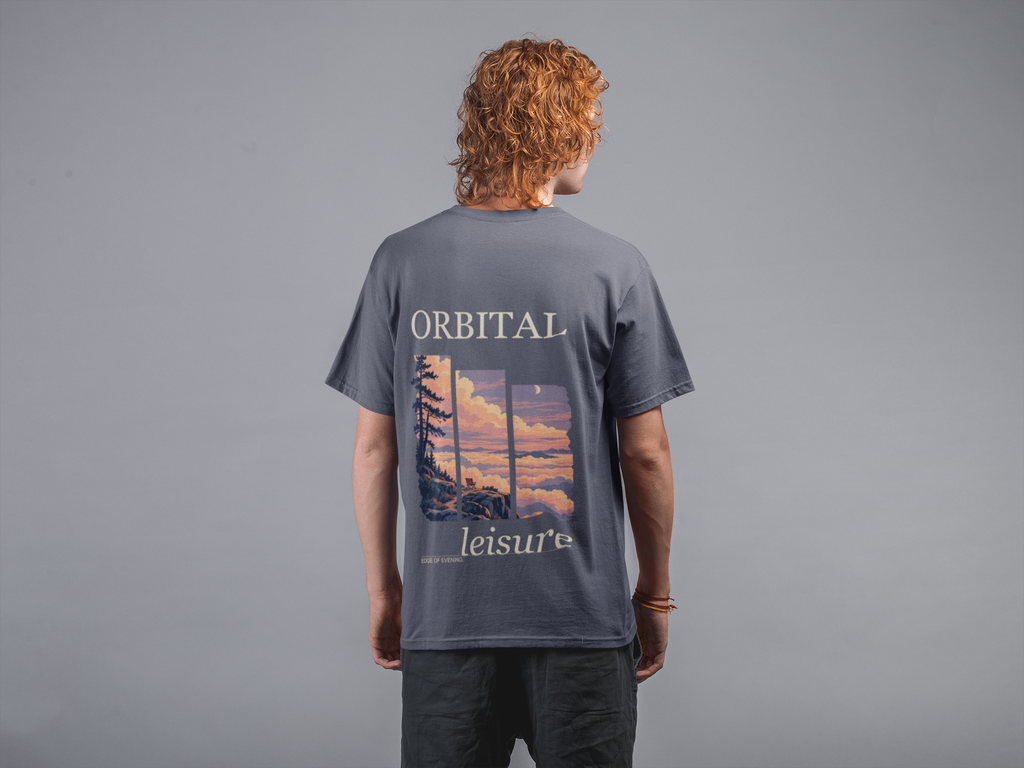 Edge of Evening Garment-Dyed Tee in Navy, worn by a man seen from behind against a plain grey wall, showing the large print on the back. Digital product mockup.