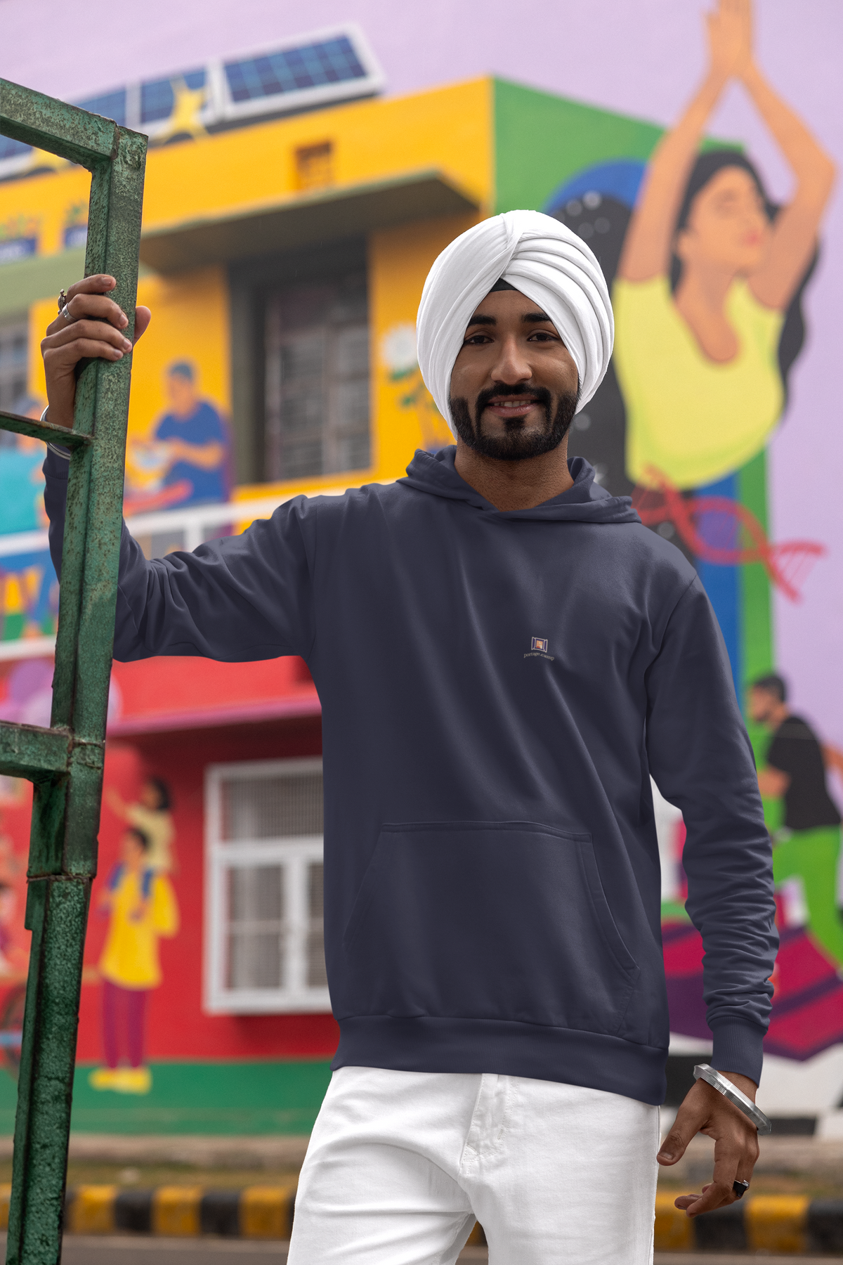 Open Late Midweight Hoodie in Classic Navy, worn by a man in a turban on a busy street, with the Open Late logo and portage.camp on the chest. Digital product mockup.