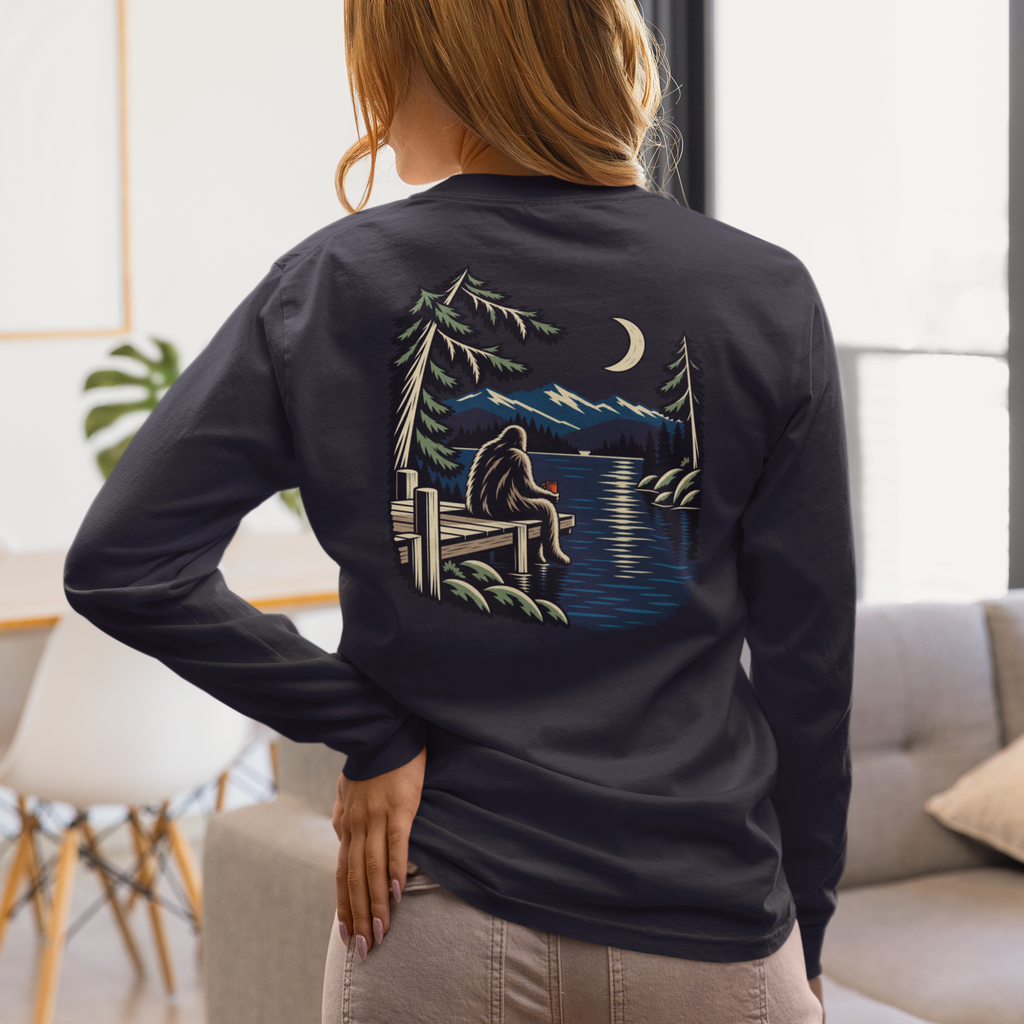 Quiet Hours Garment-Dyed Long-Sleeve Tee in True Navy, worn by a woman seen from behind at home, showing the large print on the back. Digital product mockup.