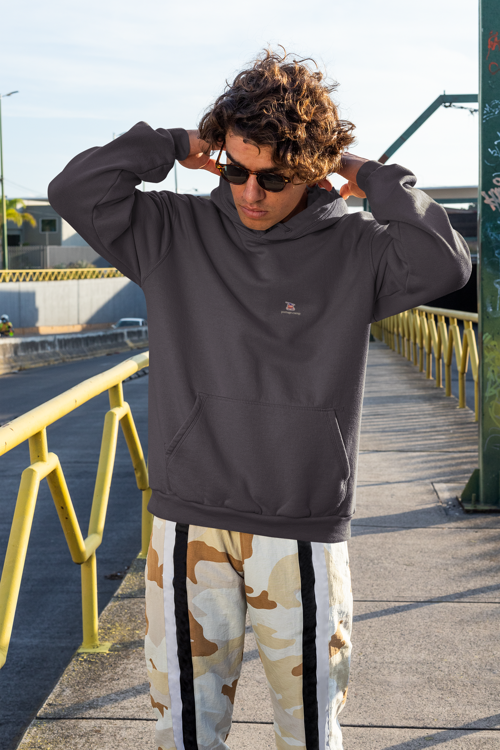 Cloud Ferry Midweight Hoodie in Black, worn by a man on a city street, with the Cloud Ferry logo and portage.camp on the chest. Digital product mockup.