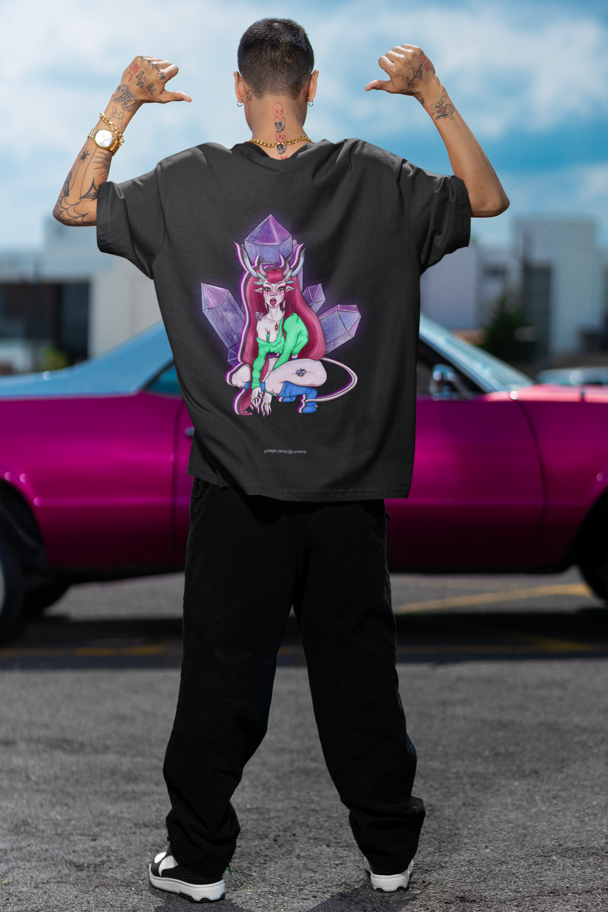 Amethyst After Hours Garment-Dyed Tee in Black, worn by a man seen from behind by a pink car, showing the large print on the back. Digital product mockup.