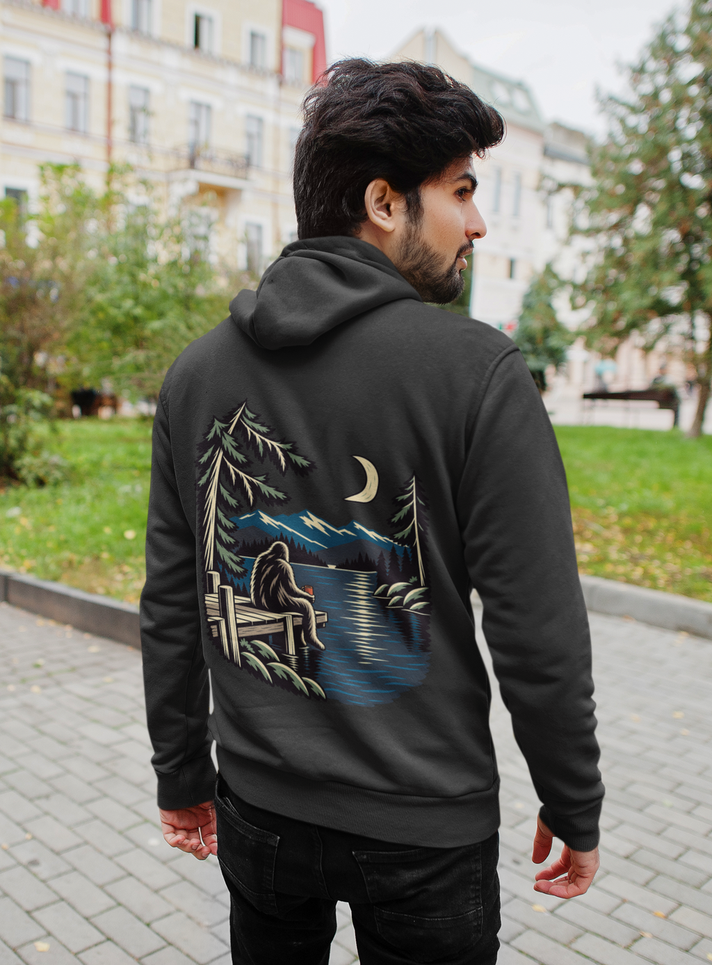 Quiet Hours Zip Hoodie in Black, worn by a man seen from behind on a quiet city street, showing the large print on the back. Digital product mockup.