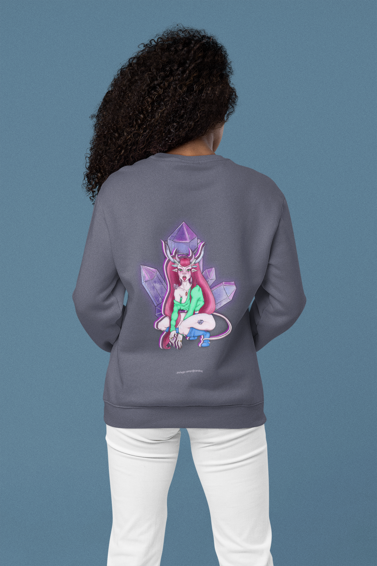 Heart Thief Garment-Dyed Crewneck in Denim, worn by a woman seen from behind in a studio, showing the large print on the back. Digital product mockup.