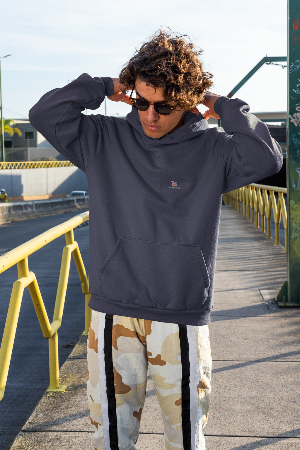 Cloud Ferry Midweight Hoodie in Classic Navy, worn by a man on a city street, with the Cloud Ferry logo and portage.camp on the chest. Digital product mockup.