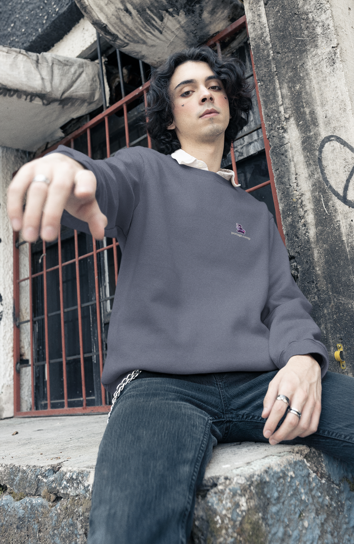 Orbit Keeper Garment-Dyed Crewneck in Denim, worn by a man in a studio, with the Orbit Keeper logo and portage.camp on the chest. Digital product mockup.