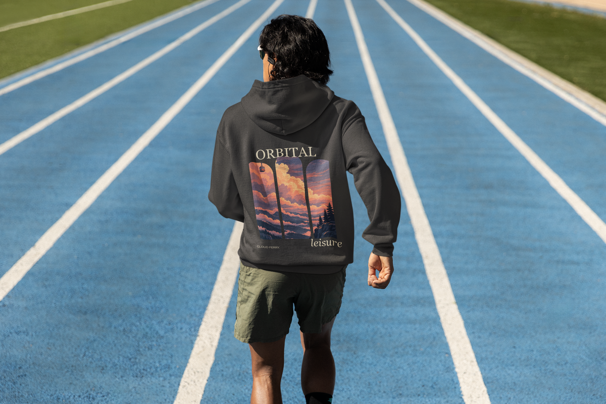 Edge of Evening Heavyweight Hoodie in Black, worn by a man seen from behind on a running track, showing the large print on the back. Digital product mockup.