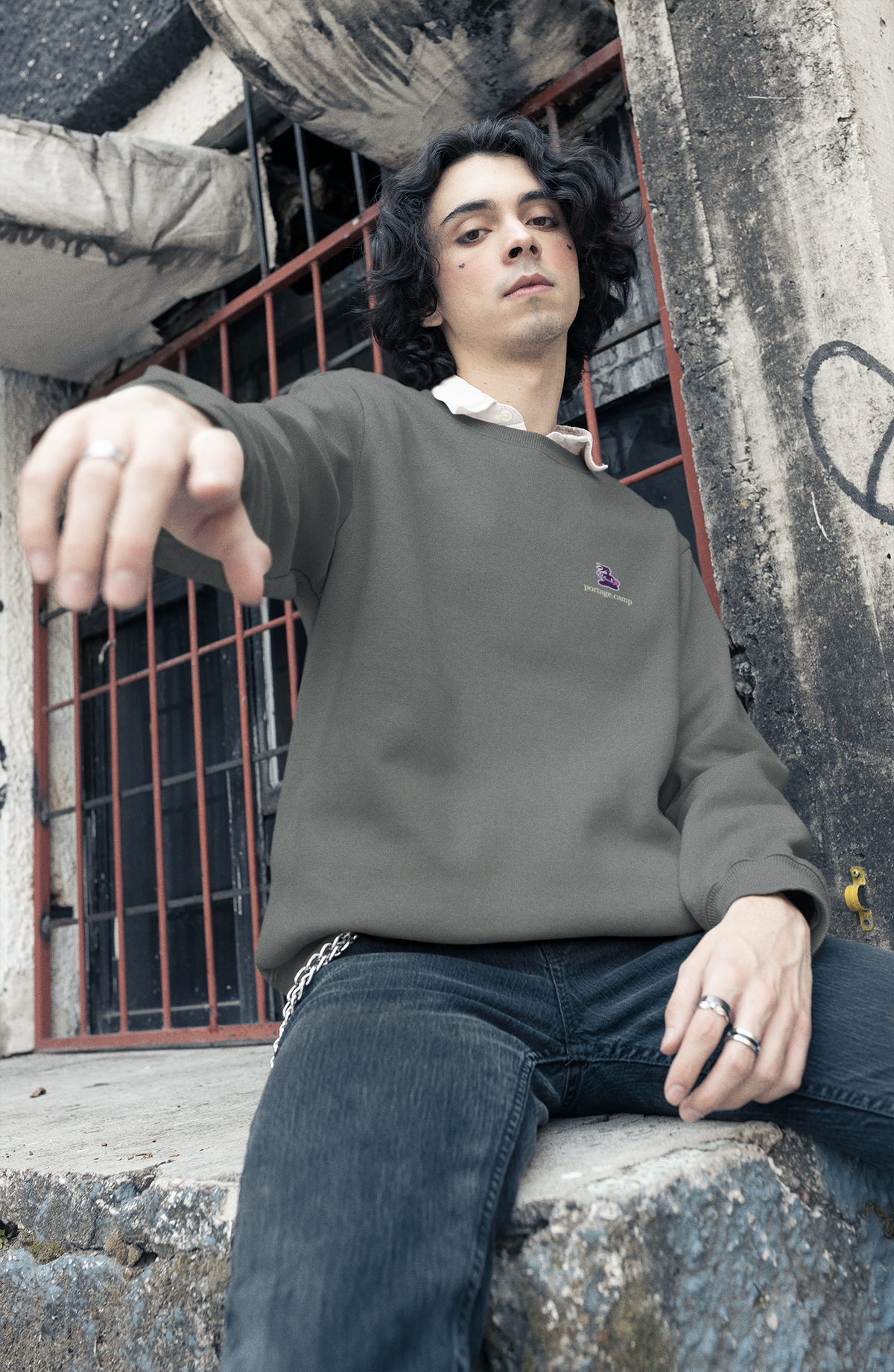 Orbit Keeper Garment-Dyed Crewneck in Pepper, worn by a man in a studio, with the Orbit Keeper logo and portage.camp on the chest. Digital product mockup.