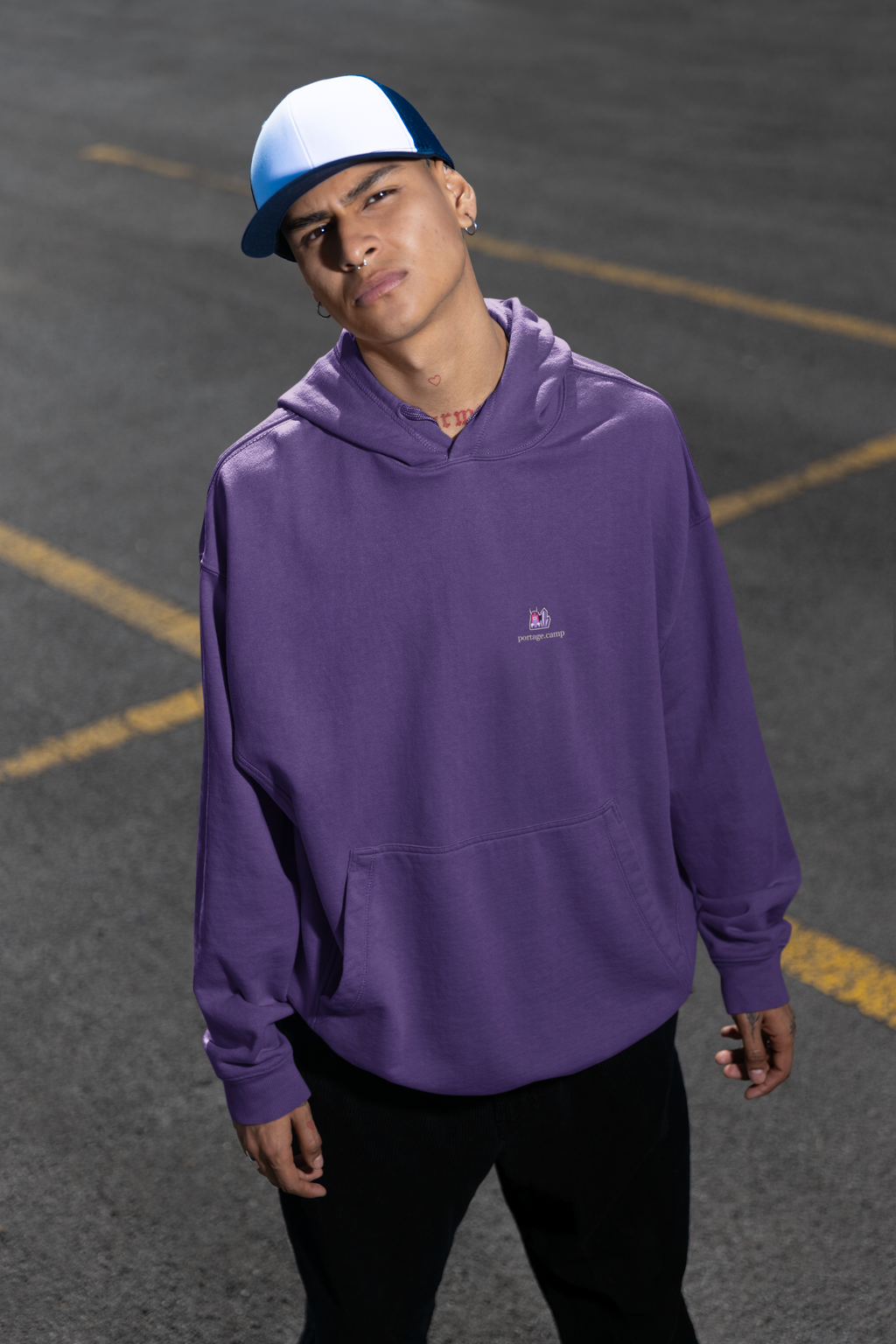 Amethyst After Hours Midweight Hoodie in Purple, worn by a man in a parking lot, with the Amethyst After Hours logo and portage.camp on the chest. Digital product mockup.