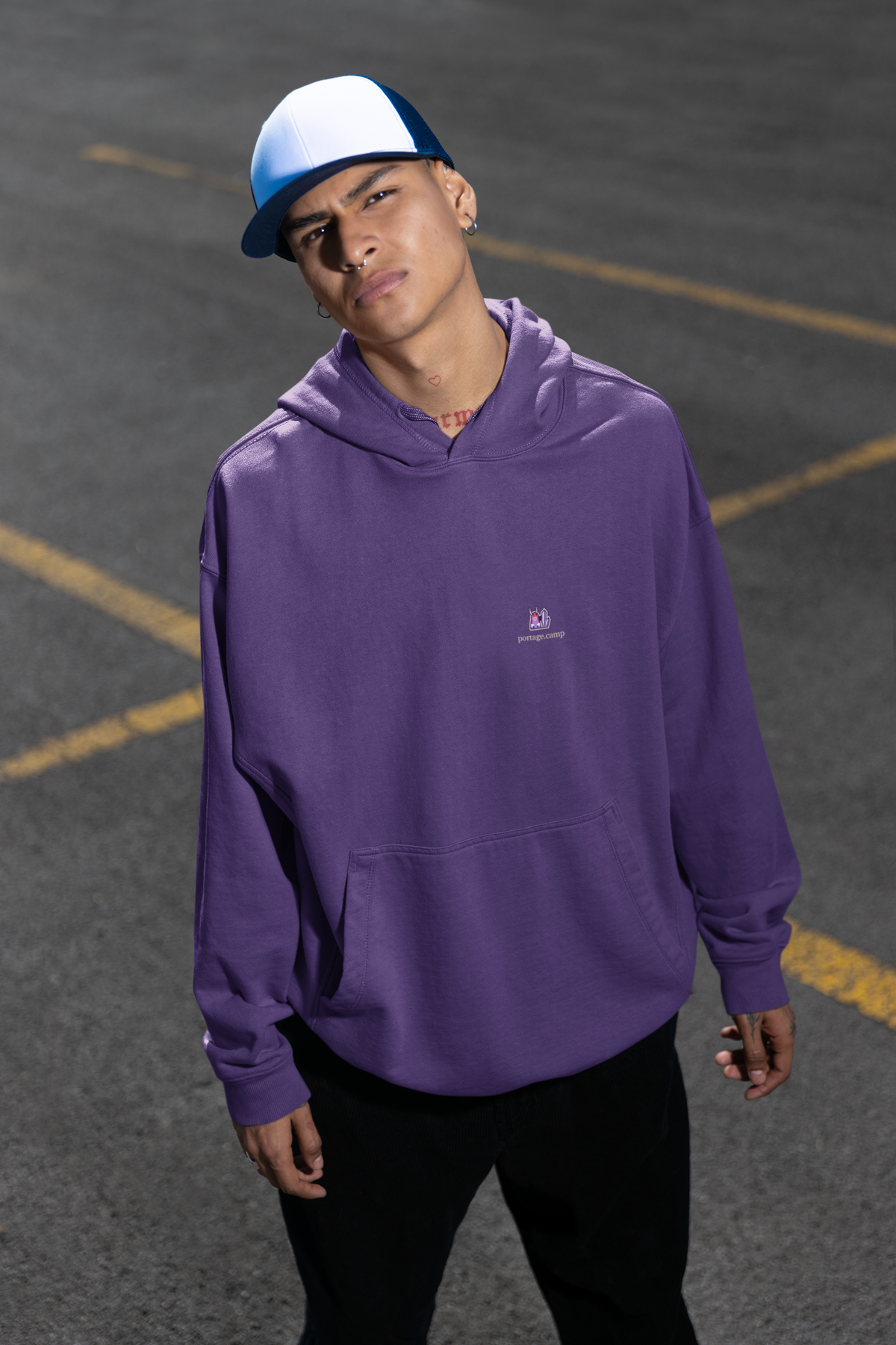 Amethyst After Hours Midweight Hoodie in Purple, worn by a man in a parking lot, with the Amethyst After Hours logo and portage.camp on the chest. Digital product mockup.