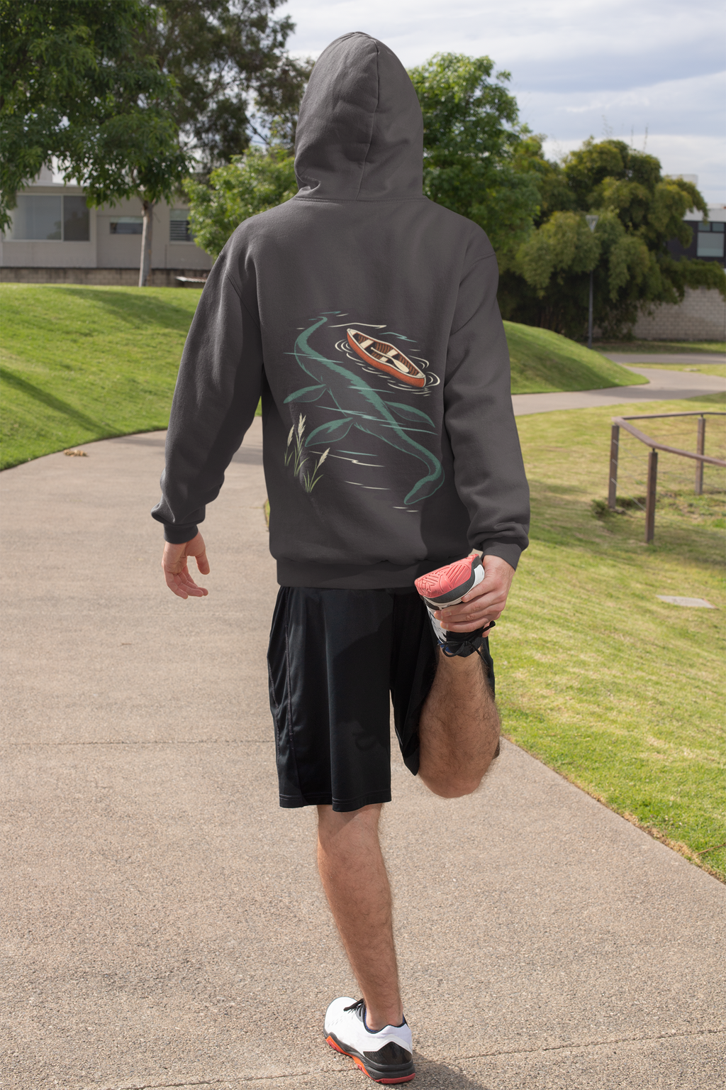 Seen Briefly Midweight Hoodie in Black, worn by a man seen from behind on a sunny path, ready for a run, showing the large print on the back. Digital product mockup.