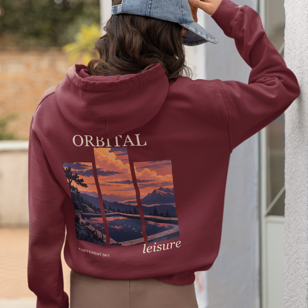 A Different Sky Midweight Hoodie in Maroon, worn by a woman seen from behind at home, showing the large print on the back. Digital product mockup.