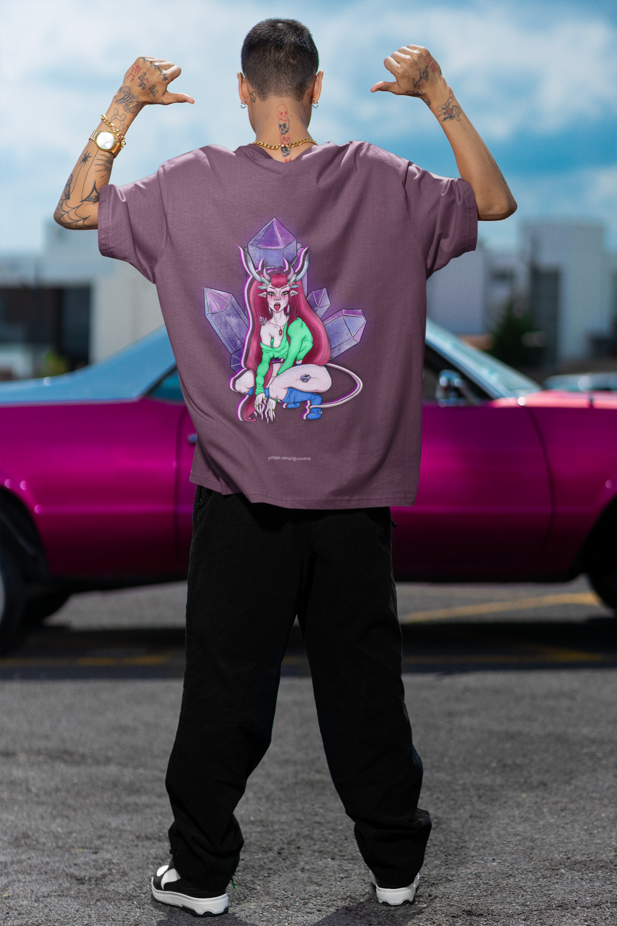 Amethyst After Hours Garment-Dyed Tee in Berry, worn by a man seen from behind by a pink car, showing the large print on the back. Digital product mockup.