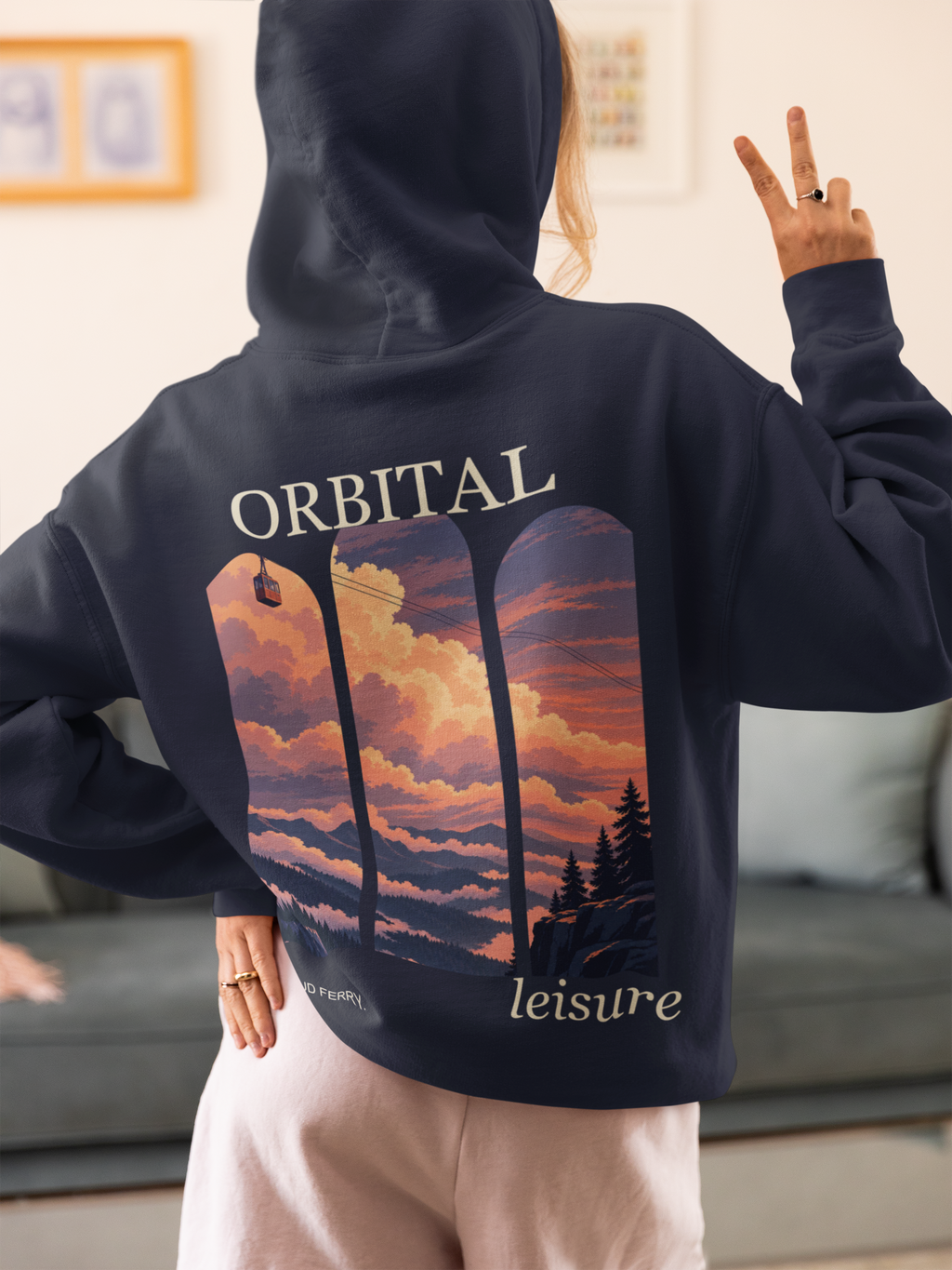 Cloud Ferry Zip Hoodie in Navy, worn by a woman seen from behind at home, making a peace sign, showing the large print on the back. Digital product mockup.