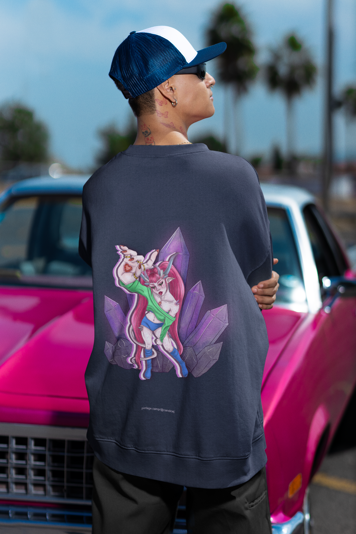 Amethyst After Hours Garment-Dyed Crewneck in True Navy, worn by a man seen from behind by a pink classic car, showing the large print on the back. Digital product mockup.