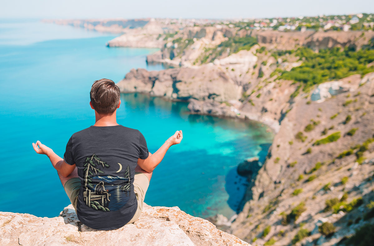 Quiet Hours Garment-Dyed Tee in Navy, worn by a man seen from behind on a misty mountain top, showing the large print on the back. Digital product mockup.