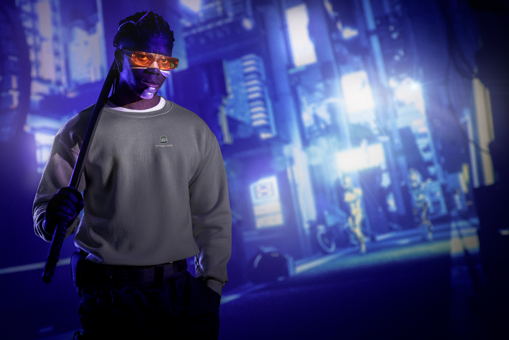 Rain Check Garment-Dyed Crewneck in Pepper, worn by a man under neon city lights, with the Rain Check logo and portage.camp on the chest. Digital product mockup.