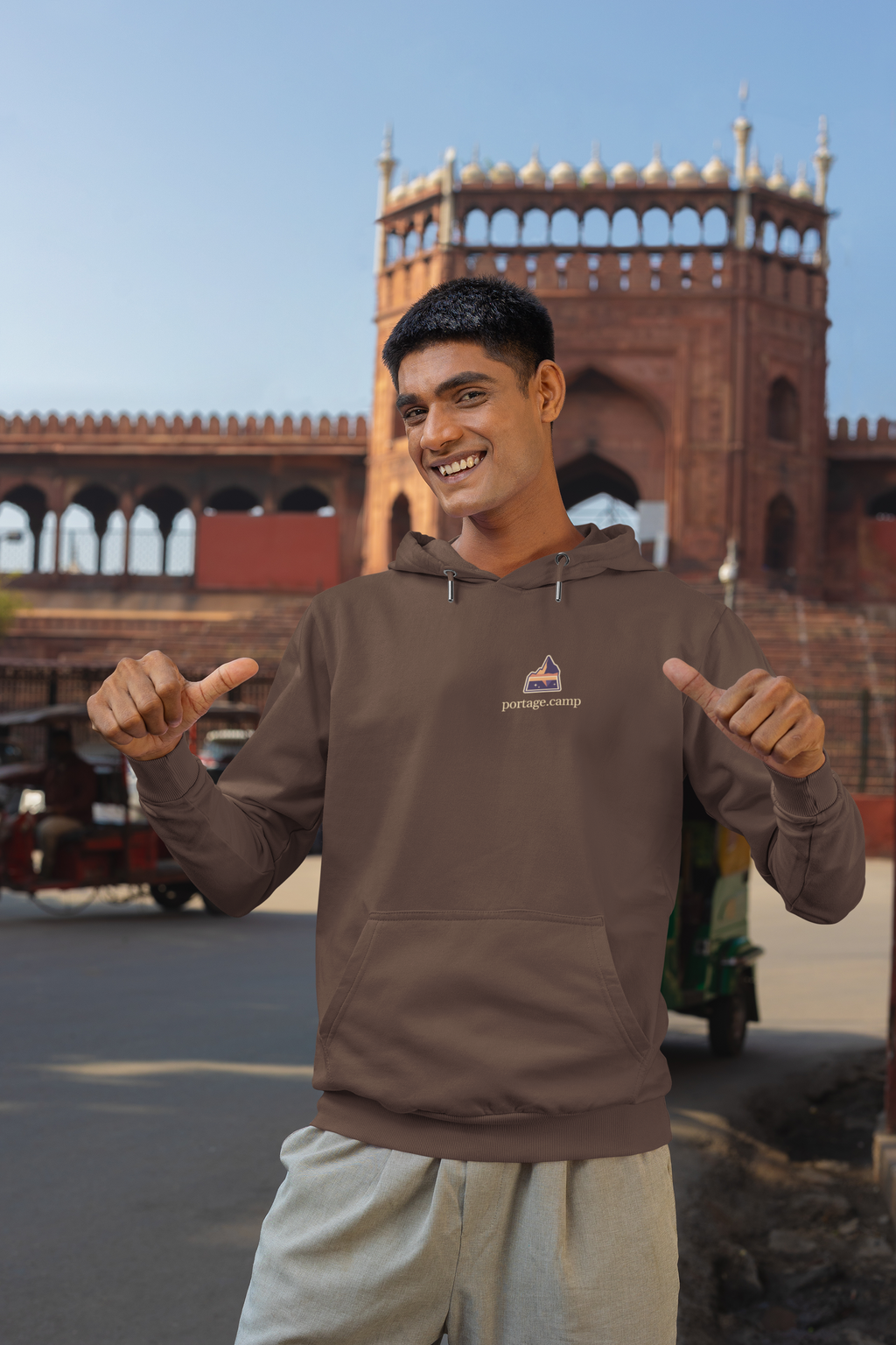 A Different Sky Heavyweight Hoodie in Brown, worn by a man on a city street, with the A Different Sky logo and portage.camp on the left chest. Digital product mockup.